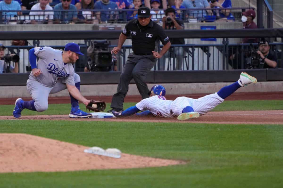 Sep 1, 2022; New York City, New York, USA; New York Mets shortstop Francisco Lindor (12) steals third base as Los Angeles Dodgers third baseman Max Muncy (13) makes a late tag during the sixth inning at Citi Field. Mandatory Credit: Gregory Fisher