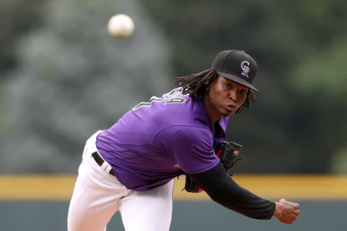 A baseball flying, with José Ureña in the background, finishing a pitch
